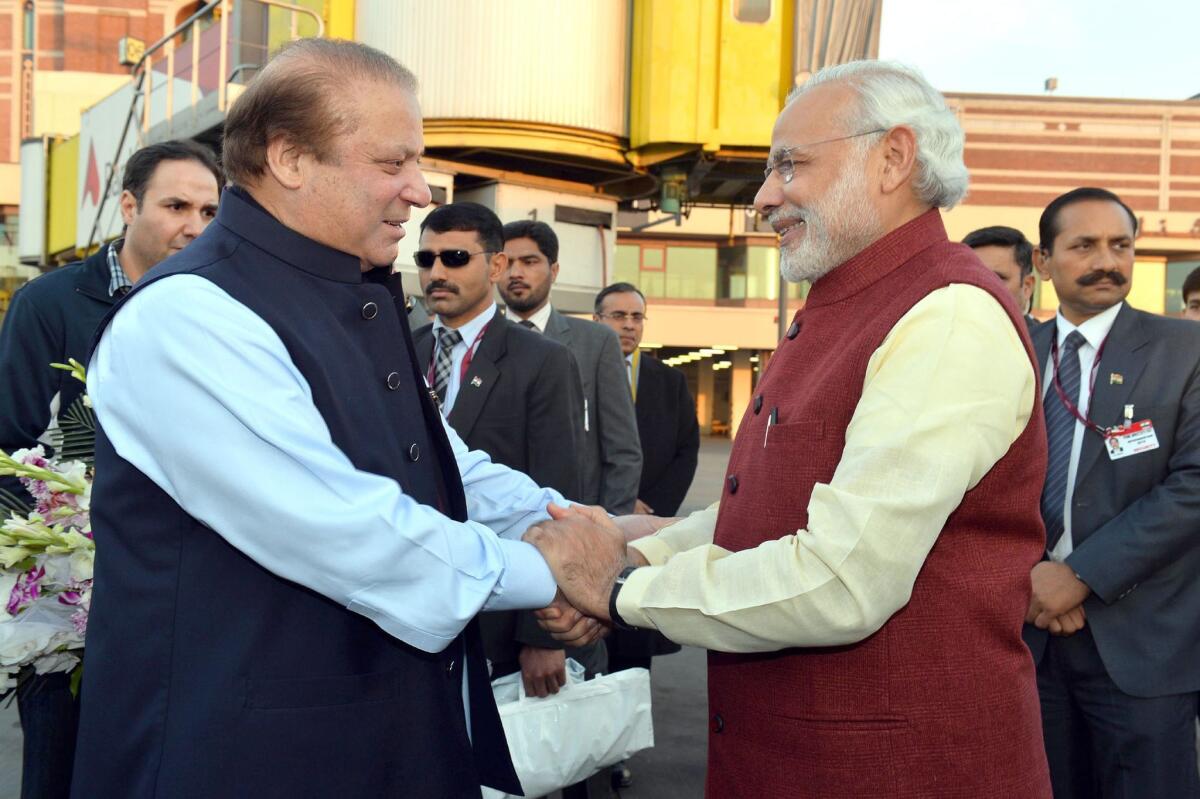 Pakistani Prime Minister Nawaz Sharif, left, welcomes Indian Prime Minister Narendra Modi at the airport in Lahore, Pakistan, on Friday. Modi made a surprise stopover in the first visit by an Indian prime minister to Pakistan since 2004.