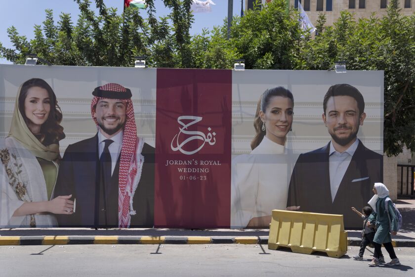 A poster with pictures of Crown Prince Hussein and his fiancee, Saudi architect Rajwa Alseif is posted at a road in Amman, Jordan, Wednesday, May 31, 2023. Crown Prince Hussein and Saudi architect Rajwa Alseif are to be married on Thursday at a palace wedding in Jordan, a Western-allied monarchy that has been a bastion of stability for decades as Middle East turmoil has lapped at its borders.(AP Photo/Nasser Nasser)