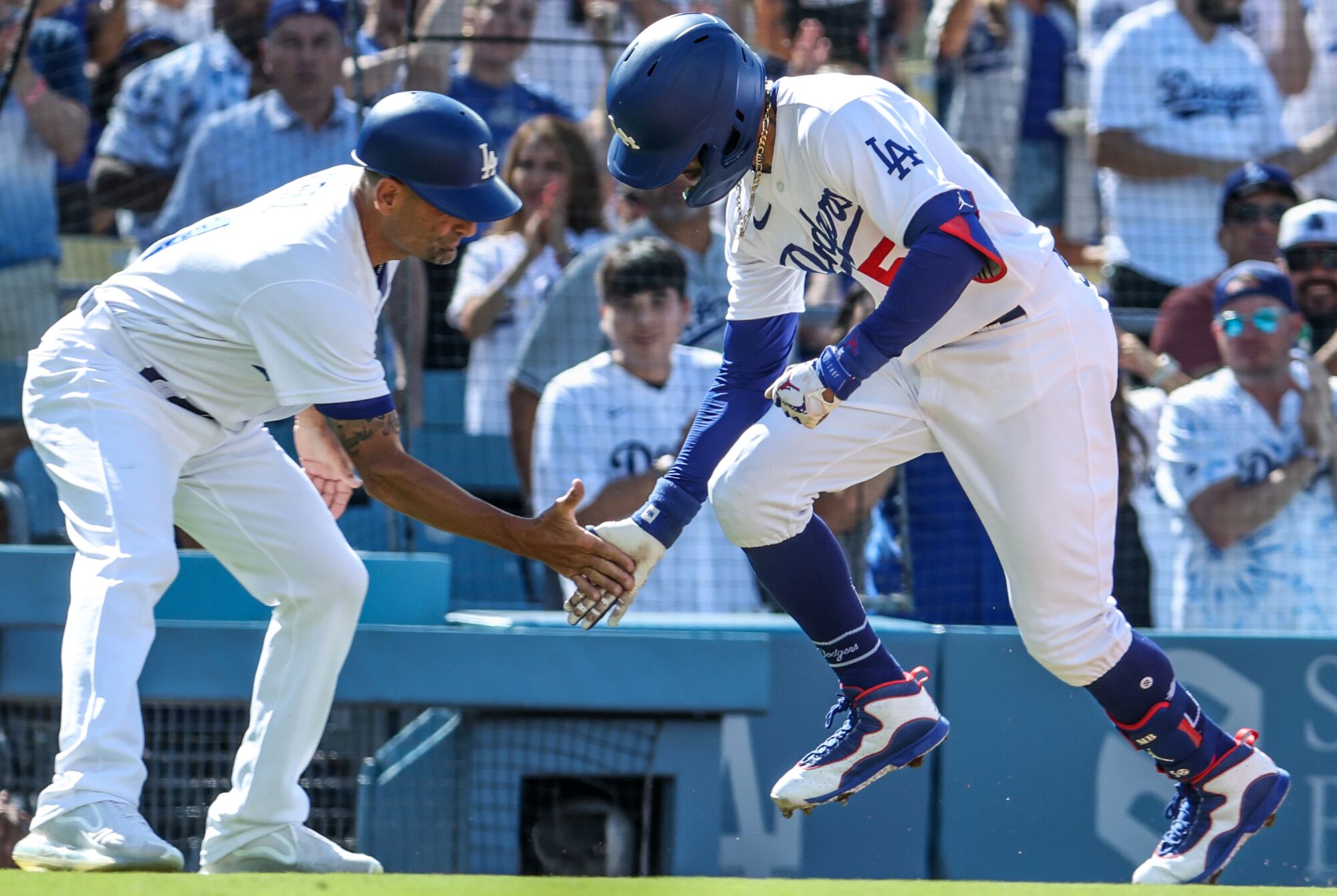 Dodgers right fielder Mookie Betts celebrates a homer with third base coach Dino Ebel on June 25, 2023, at Dodger Stadium.
