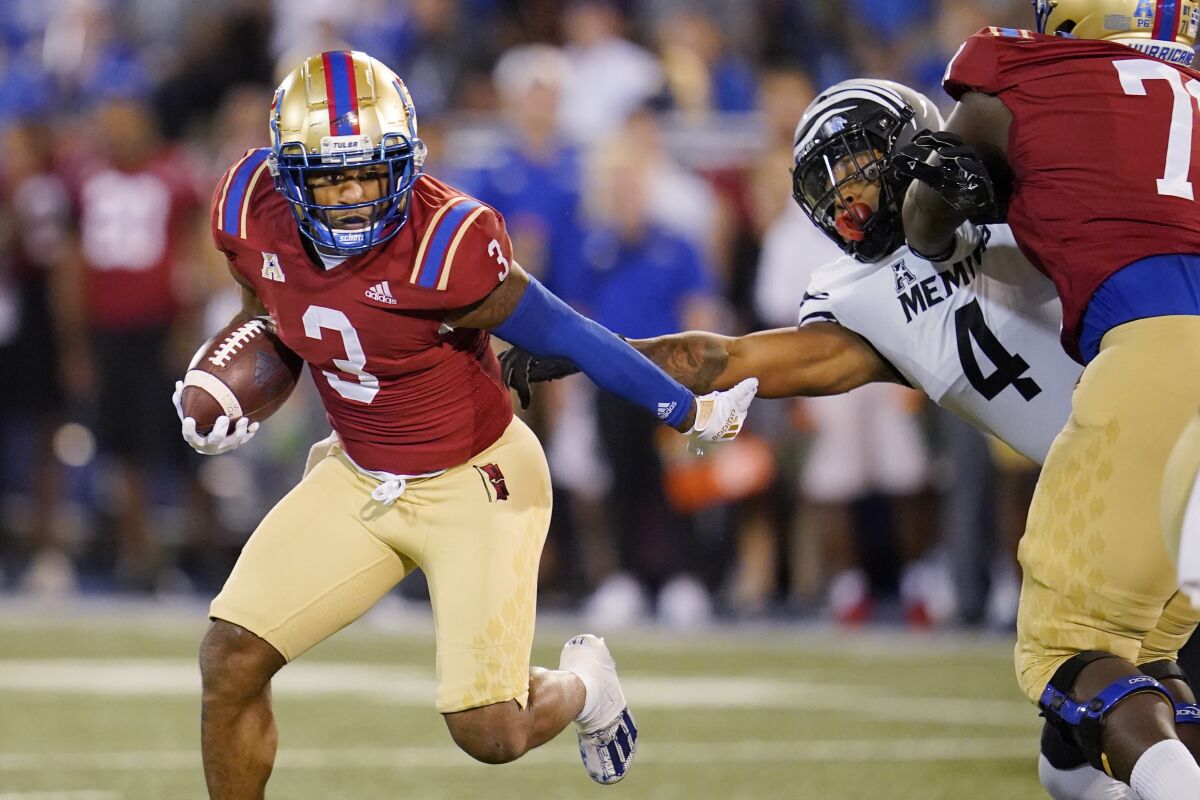 Tulsa running back Shamari Brooks (3) carries the ball past Memphis defensive lineman Maurice White (4) in the first half of an NCAA college football game Saturday, Oct. 9, 2021, in Tulsa, Okla. (AP Photo/Sue Ogrocki)