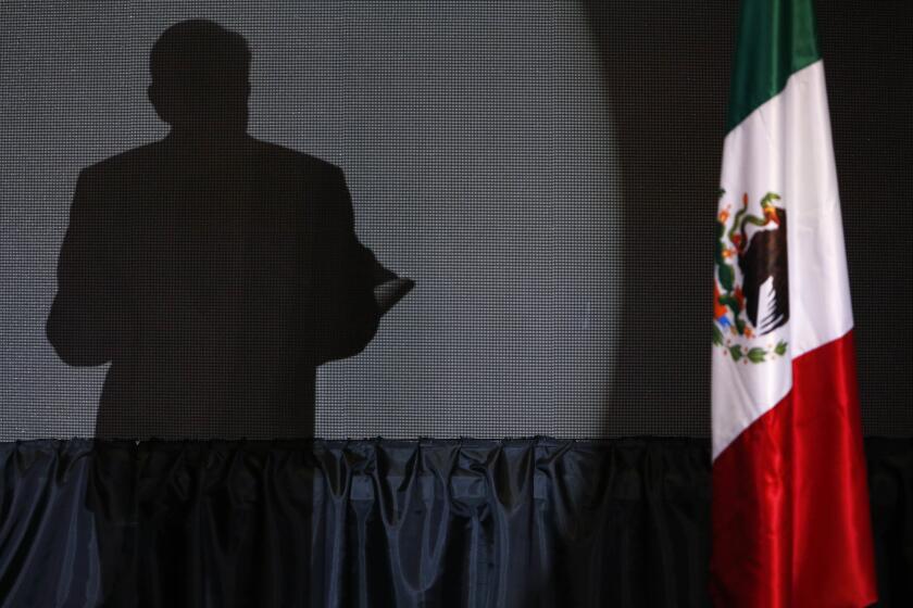 FILE - The shadow of presidential candidate Andres Manuel Lopez Obrador, founder of the ruling party, Morena, is cast on a screen as he gives his first victory speech at his campaign headquarters at the Hilton hotel in Mexico City, late July 1, 2018. (AP Photo/Marco Ugarte, File)