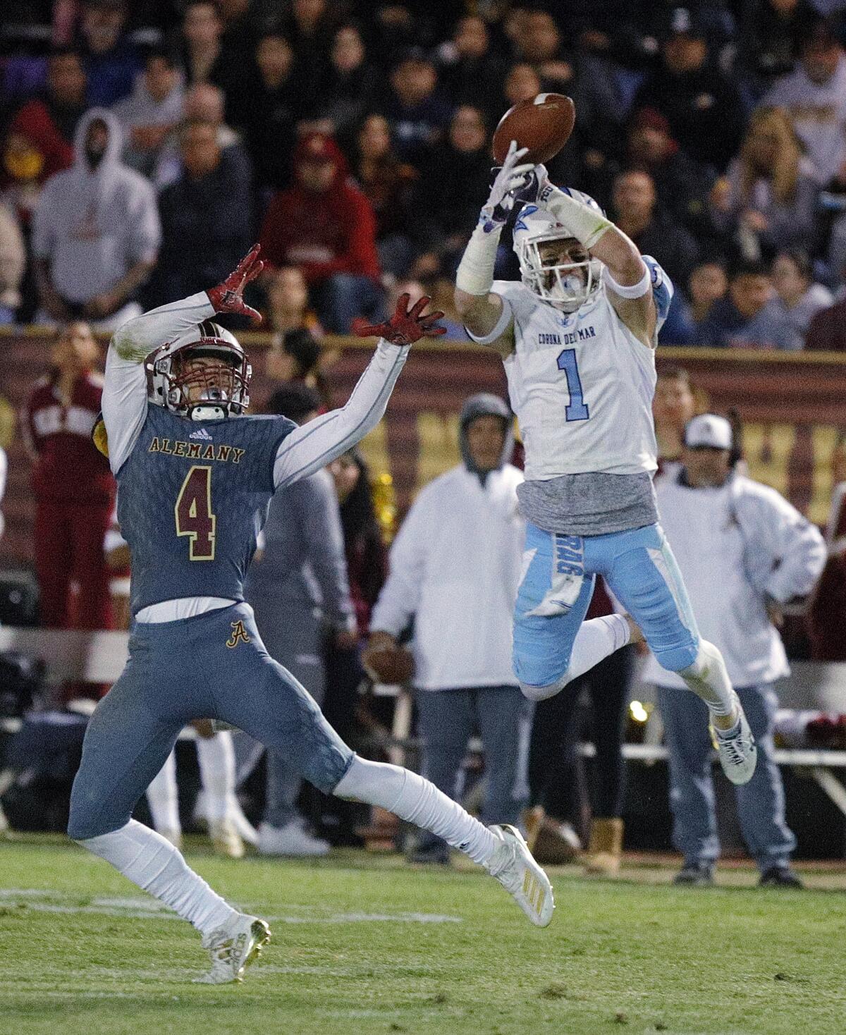 Corona del Mar's Chandler Fincher tips the ball in the air on a pass to Alemany's DJ Justice and intercepts it in a CIF Southern Section Division 3 semifinal game in Mission Hills on Friday.