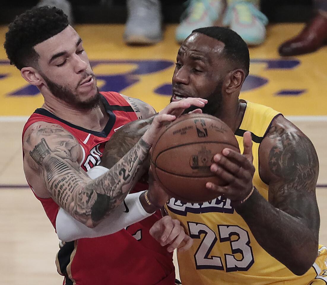 The Pelicans' Lonzo Ball, facing his former team, fouls the Lakers' LeBron James on Friday night at Staples Center. Ball scored 23 points, and James had 17 points and 15 assists.