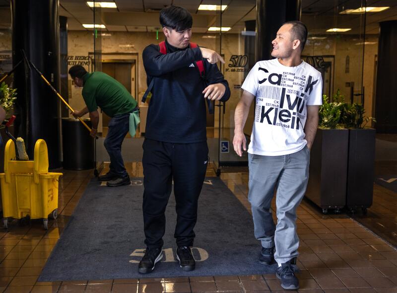 Javier Diaz Santana, right, and friend Bryan exit the Heron Building in downtown L.A.