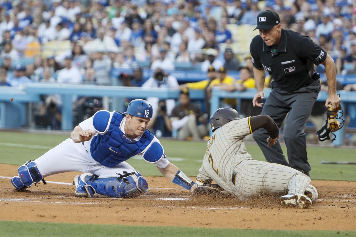 Dodgers catcher Will Smith tags out San Diego's Trent Grisham at home plate.