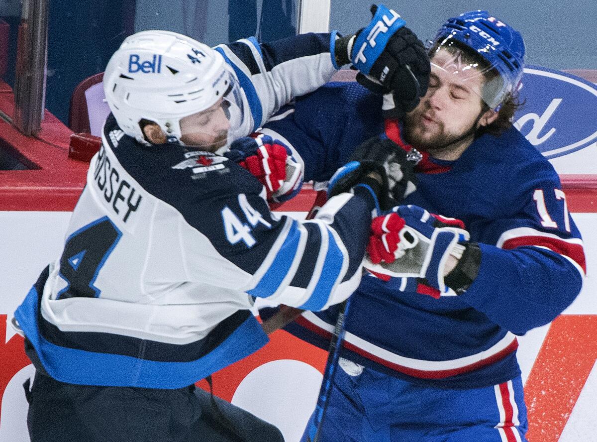 Montreal Canadiens' Josh Anderson (17) collides with Winnipeg Jets' Josh Morrissey during first-period NHL hockey game action in Montreal, Saturday, April 10, 2021. (Graham Hughes/The Canadian Press via AP)