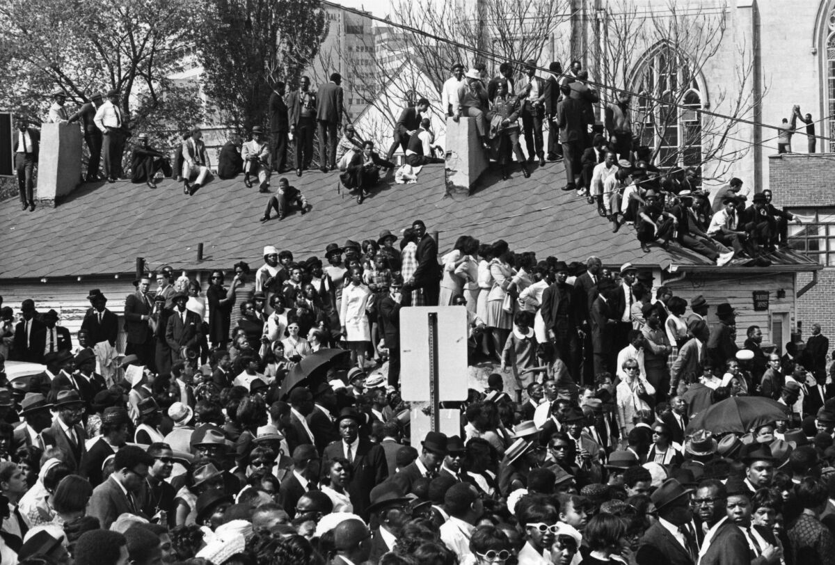 Crowds gathered on rooftops near Ebenezer Baptist Church in Atlanta during King's funeral.
