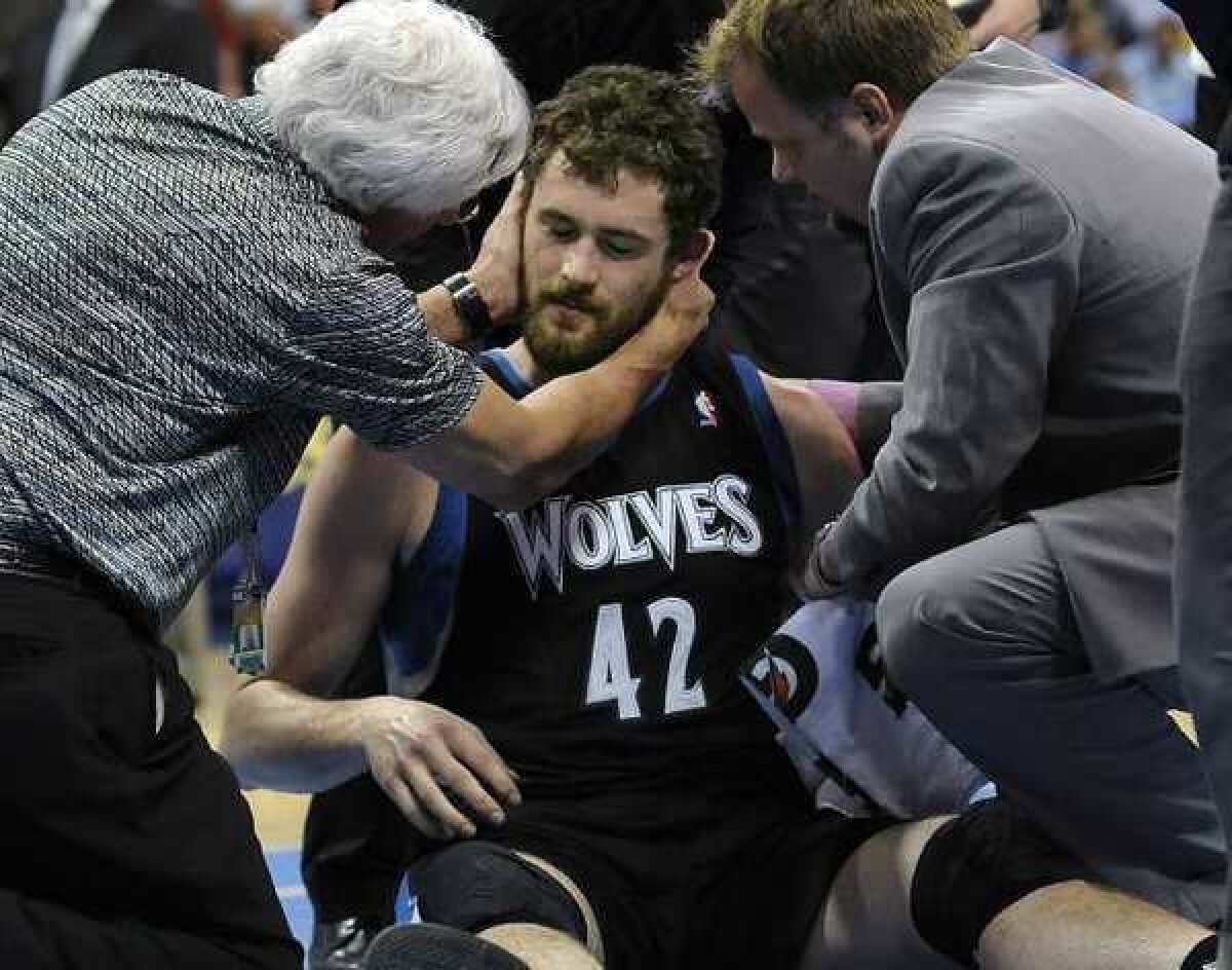 Minnesota Timberwolves forward Kevin Love is examined by a doctor after he took an elbow to the head.