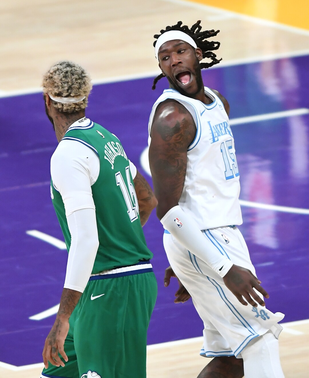 L'attaccante dei Lakers Montrezl Harrell festeggia dopo aver segnato davanti all'attaccante dei Mavericks James Johnson.