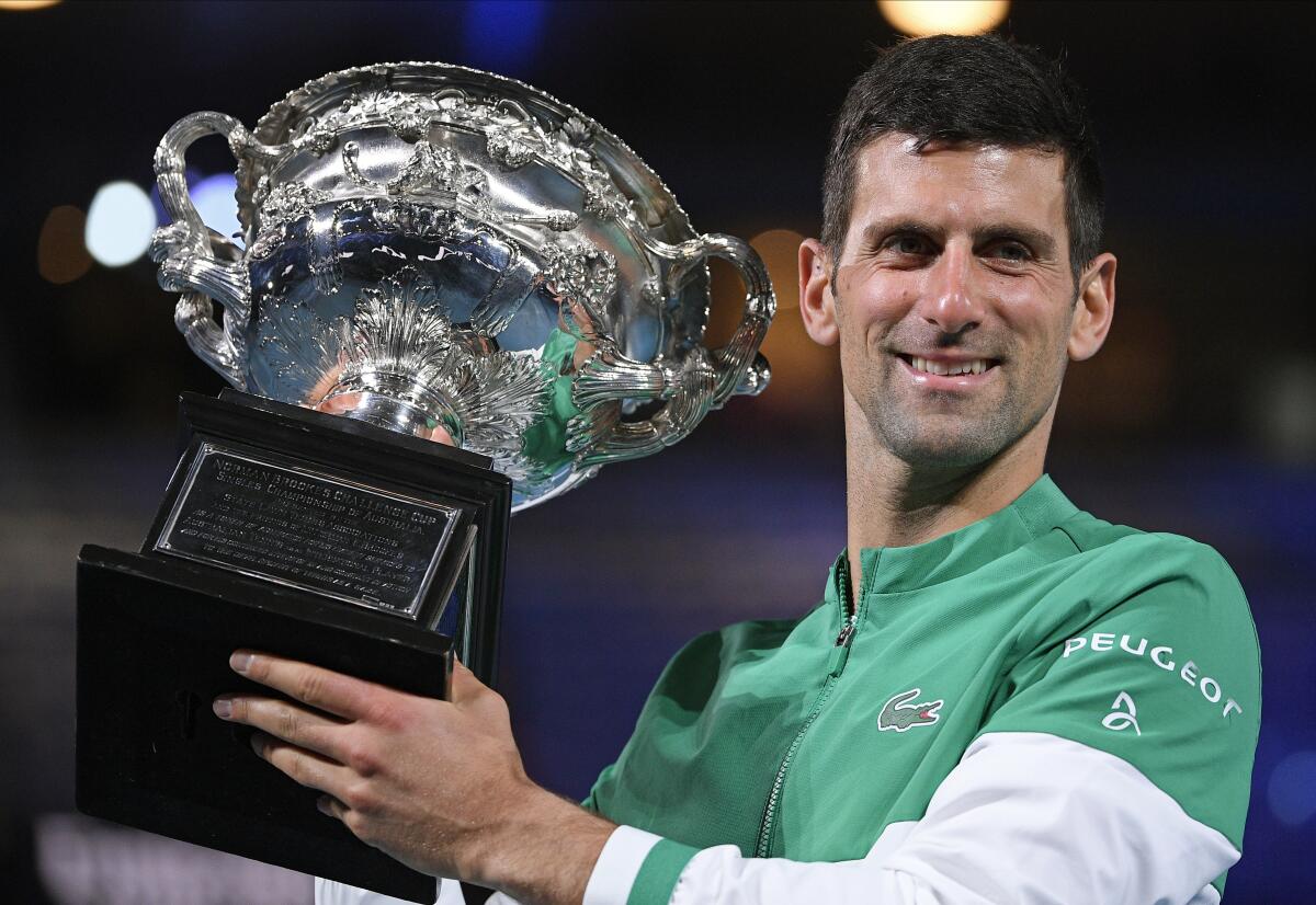 Novak Djokovic holds the Norman Brookes Challenge Cup after winning the Australian Open last year. 