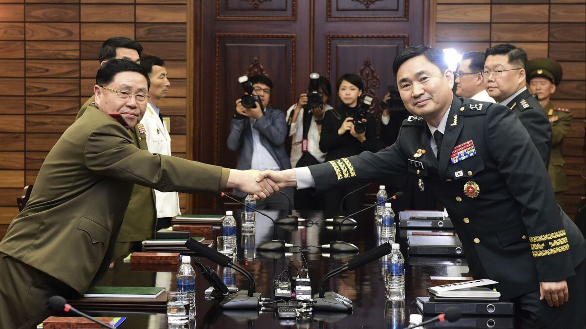 South Korean Maj. Gen. Kim Do-gyun, right, shakes hands with his North Korean counterpart, Lt. Gen. An Ik San, in high-level military talks at the northern side of Panmunjom in the Demilitarized Zone on June 14.