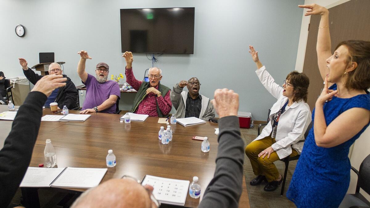 Samantha Elandary, right, the founder and CEO of the Parkinson Voice Project, and Lynn Gallandt, a speech therapist with the Los Alamitos Medical Center, lead a therapy session of Parkinson's disease patients at the hospital on March 13.