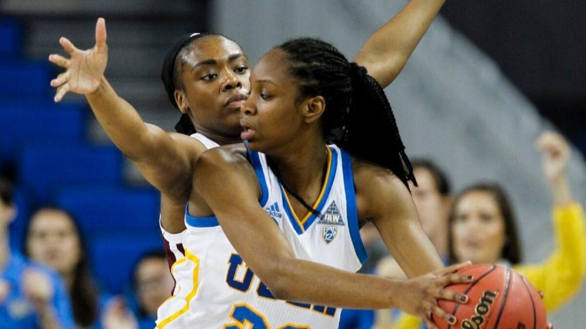 UCLA guard Dominique Williams, right, keeps the ball away from Texas A&M forward Anriel Howard during a second-round game in the NCAA tournament on March 20.