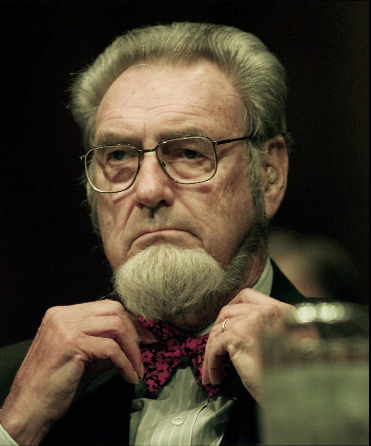 Former Surgeon General C. Everett Koop adjusts his bow tie before the start of the Committee on Agriculture hearing Sept. 11, 1997, at the Capitol. Koop attended the hearing to examine the implications of the proposed tobacco settlement.