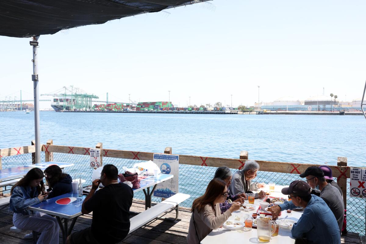 People eat outside on the dock at the San Pedro Fish Market