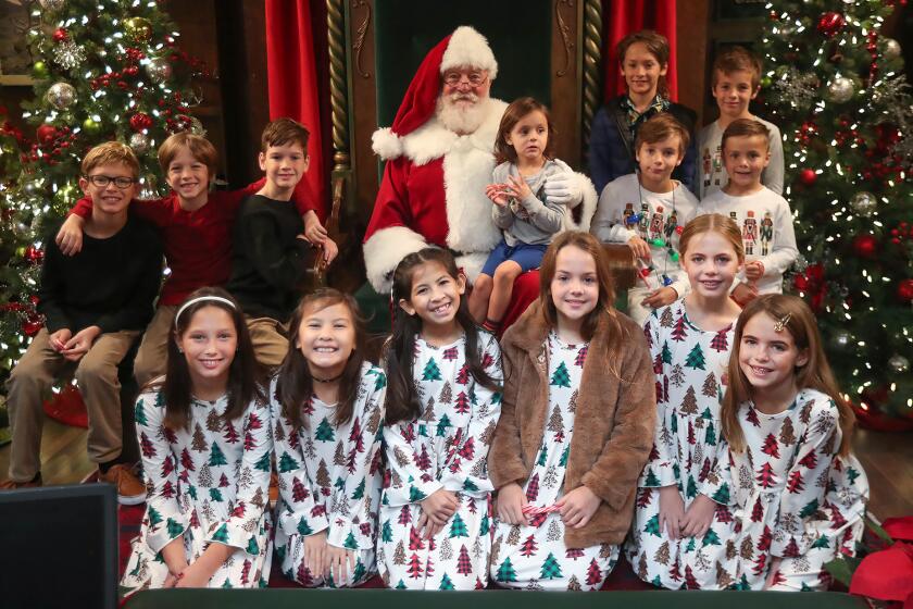 Groups of siblings get a picture with Santa during the Orange Coast and Saddleback Mothers of Multiples Clubs breakfast and visit with Santa at South Coast Plaza's Carousel Court on Thursday.