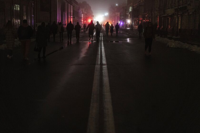 People walk at the city center which lost electrical power after yesterday's Russian rocket attack in Kyiv, Ukraine, Thursday, Nov. 24, 2022. (AP Photo/Evgeniy Maloletka)