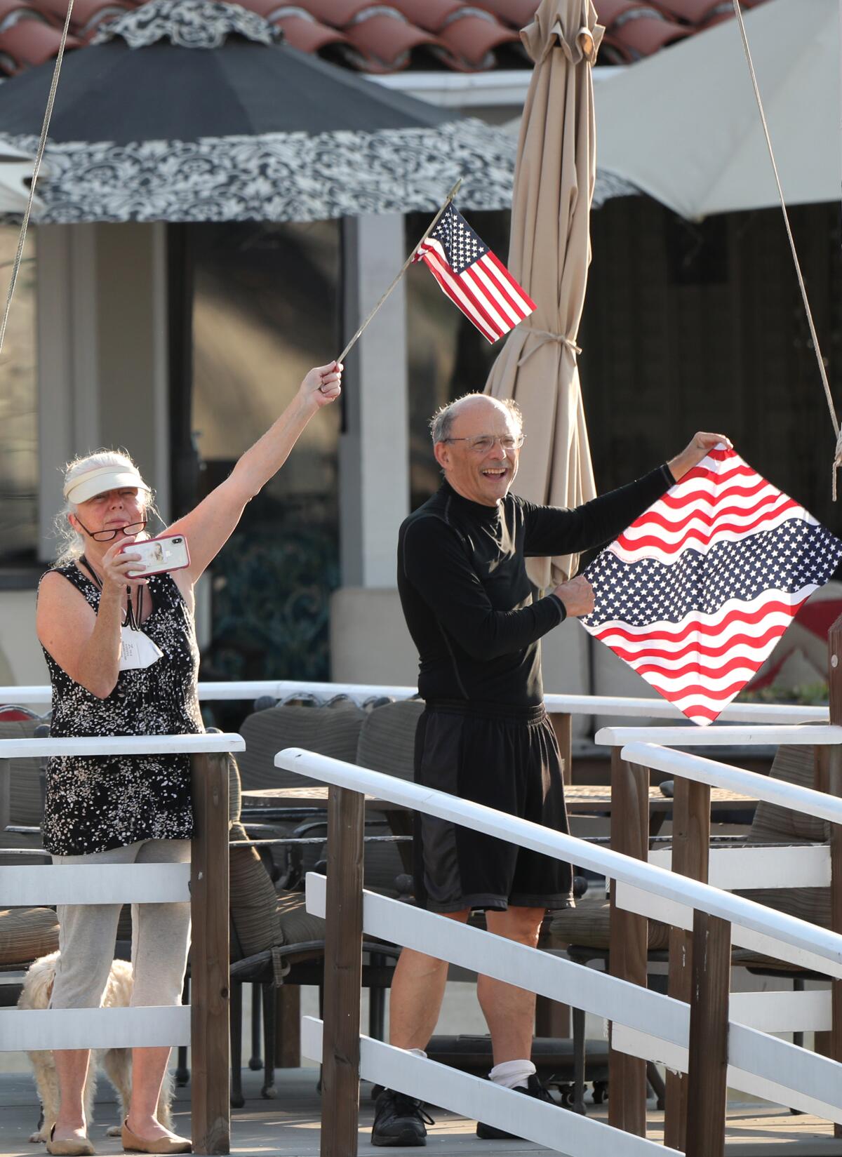 Onlookers wave flags to the passing boats.