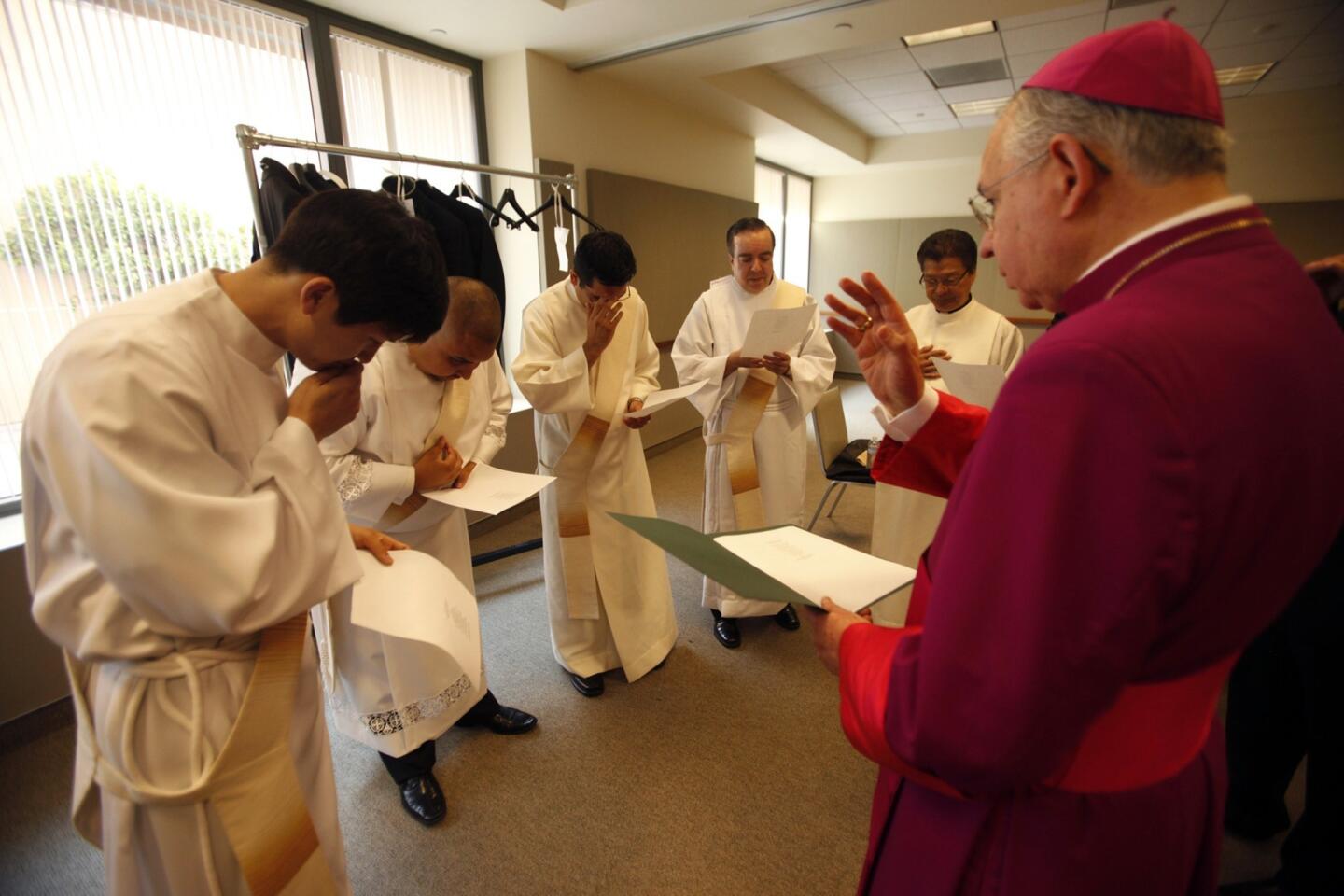 Los Angeles Archbishop Jose H. Gomez blesses Andrew Chung, left, Christopher Felix, Juan Ochoa and John Palmer before their ordination to the priesthood at the Cathedral of Our Lady of the Angels. Father Alex Aclan, second from right, was also in attendance.