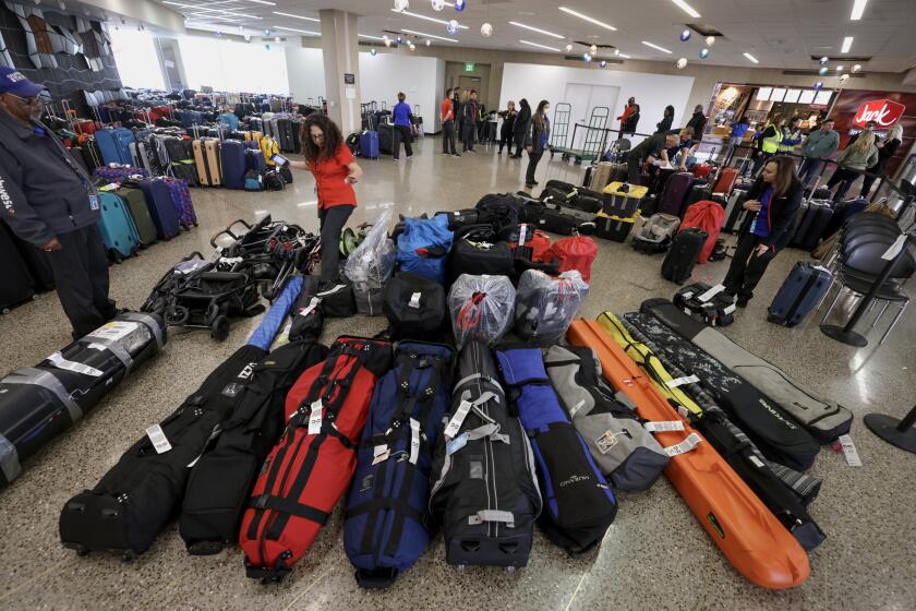 SAN DIEGO, CA - DECEMBER 29, 2022: Southwest Airlines employees look through an area filled with misplaced bags as they work to reconnect Southwest passengers with their bags at the San Diego International Airport in San Diego on Thursday, December 29, 2022. (Hayne Palmour IV / For The San Diego Union-Tribune)
