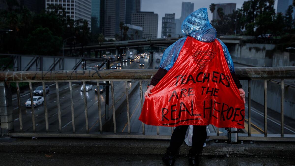 A supporter of the UTLA strike sports a cape with a message in support of educators.