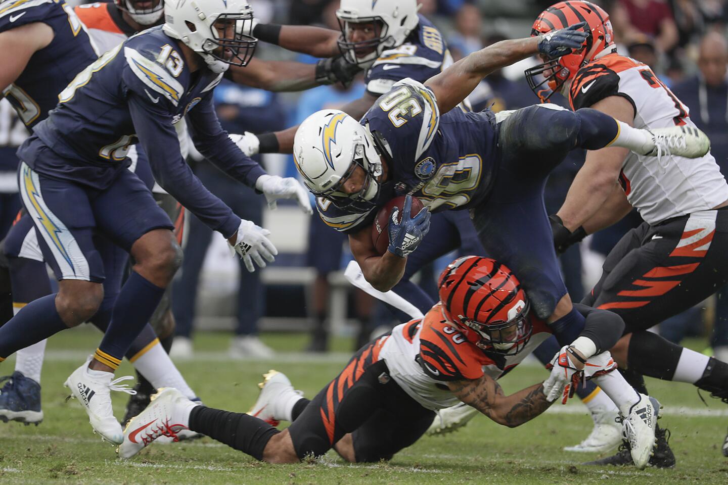 Chargers running back Austin Ekeler is stopped for a short gain by Bengals linebacker Jordan Evans.