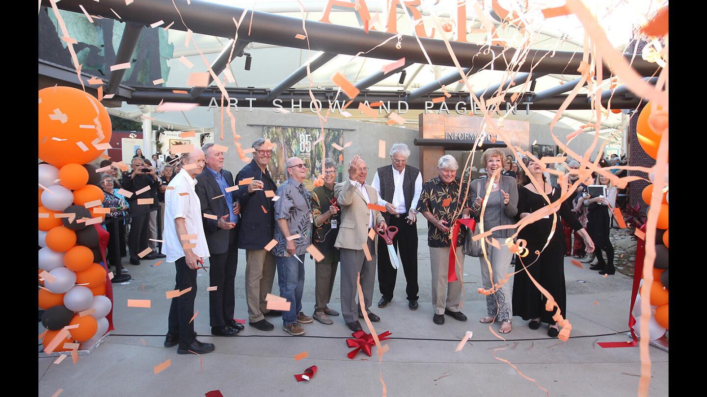 Members of the Festival of Arts board and dignitaries cut the ribbon as confetti falls during the grand opening of the renovated Festival of Arts grounds at an artists' preview night party on Monday.
