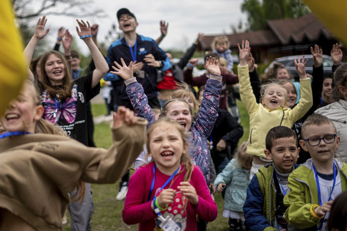 Children dance at the recovery camp for children and their mothers affected by the war near Lviv, Ukraine, Wednesday, May 3, 2023. A generation of Ukrainian children have seen their lives upended by Russia's invasion of their country. Hundreds of kids have been killed. For the survivors, the wide-ranging trauma is certain to leave psychological scars that will follow them into adolescence and adulthood. UNICEF says an estimated 1.5 million Ukrainian children are at risk of mental health issues. (AP Photo/Hanna Arhirova)