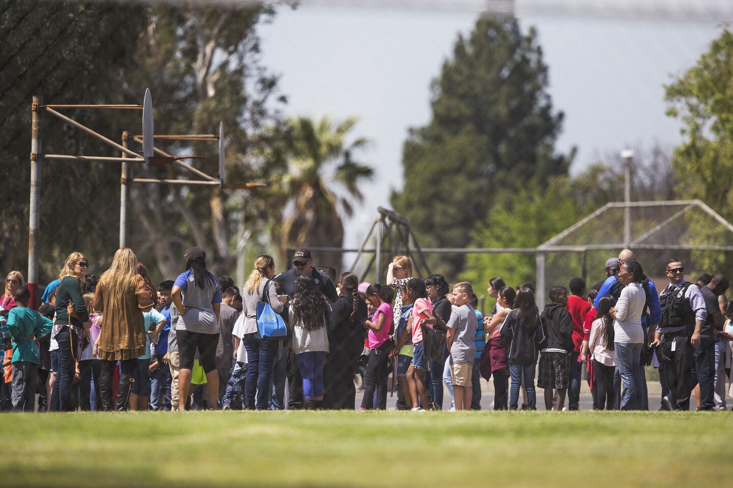 Evacuated students and teachers gather on the playground after a shooting inside North Park Elementary School in San Bernardino.