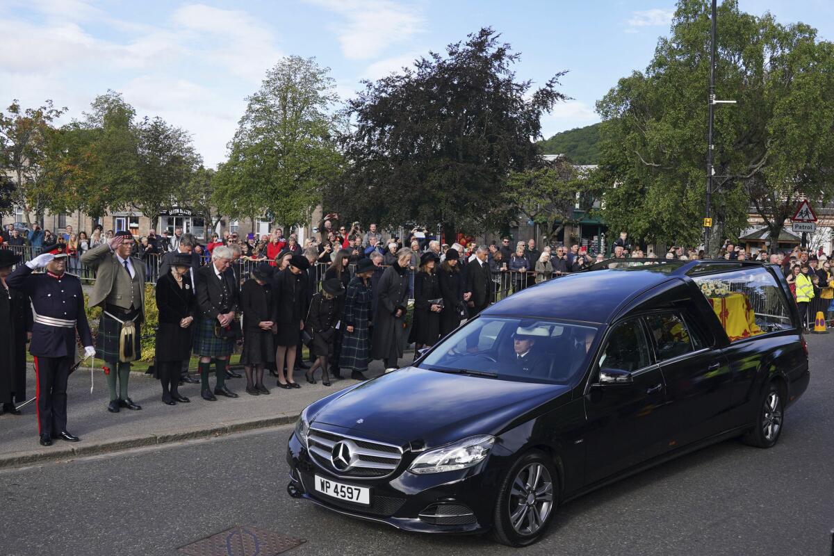 Ciudadanos en Ballater, Escocia, al paso del auto fúnebre de la reina Isabel II en su recorrido desde Balmoral a Edimburgo