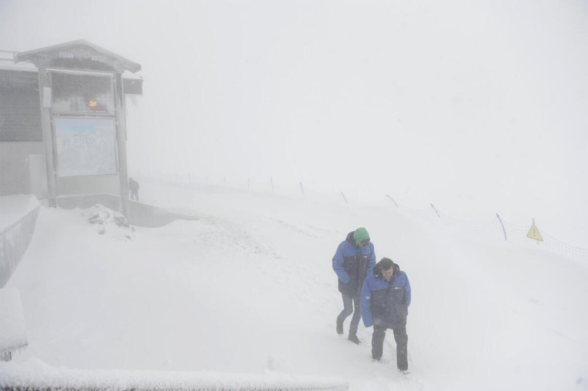 Workers brave strong wind and snowfall in Sochi.