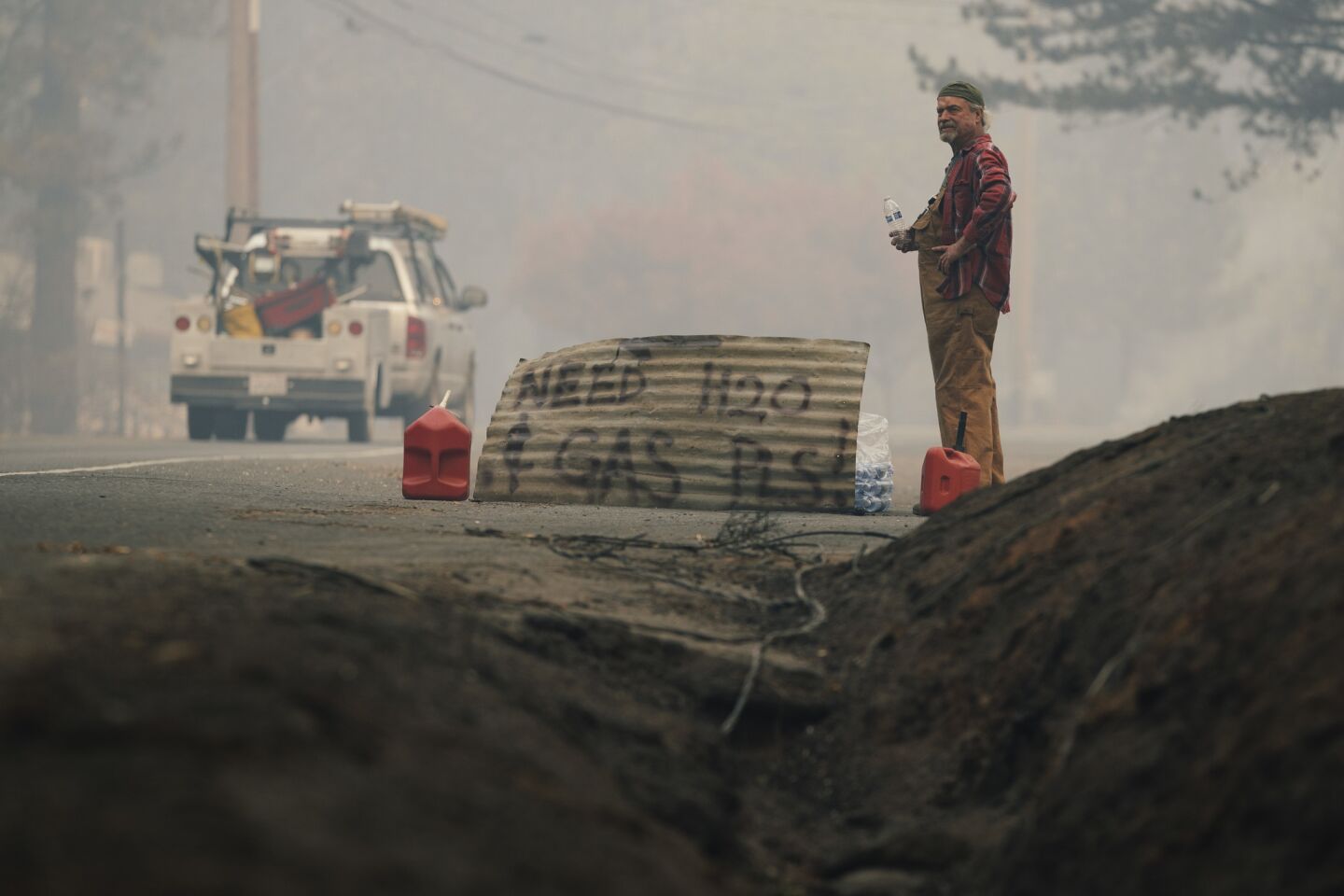 Brad Weldon, 63, waits for help along Skyway in Paradise, Calif. Weldon was among the residents who stayed and battled the wildfire.