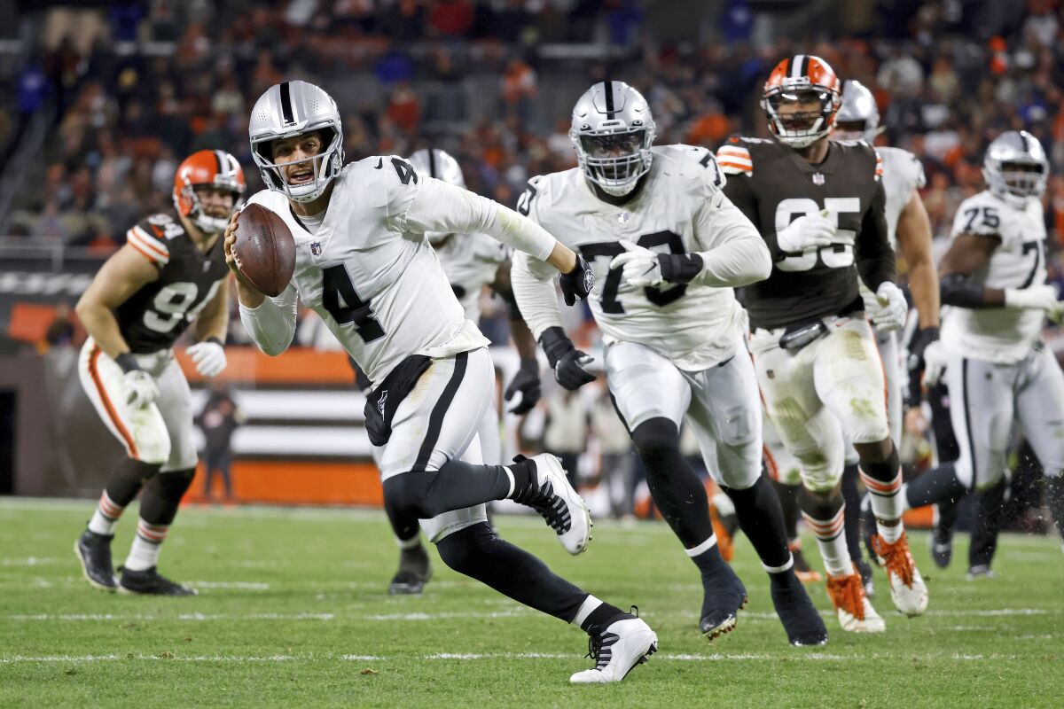 FILE - Las Vegas Raiders quarterback Derek Carr (4) runs with the ball during an NFL football game against the Cleveland Browns on Monday, Dec. 20, 2021, in Cleveland. The Raiders have given Carr a three-year contract extension, a person with knowledge of the deal tells The Associated Press. The extension is worth $121.5 million, the person said, speaking Wednesday, April 13, 2022, on condition of anonymity because the deal has not been announced. (AP Photo/Kirk Irwin, File0