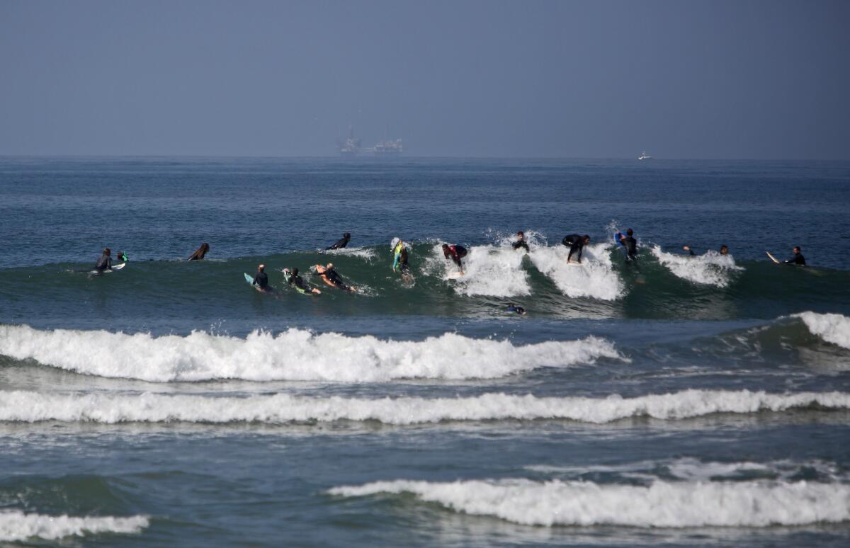 There were dozens of surfers who took to the waves next to the pier in Huntington Beach on May 2, despite a state closure order..
