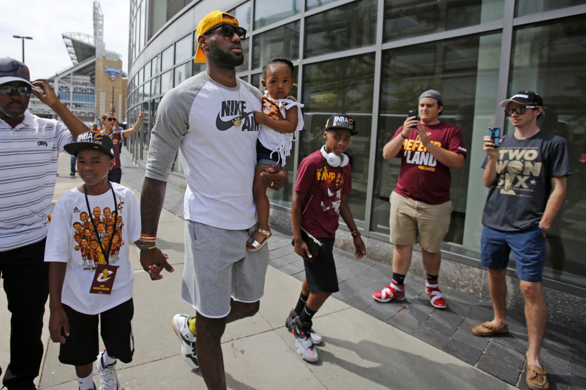 LeBron James and his children arrive at Quicken Loans Arena for Wednesday's parade.