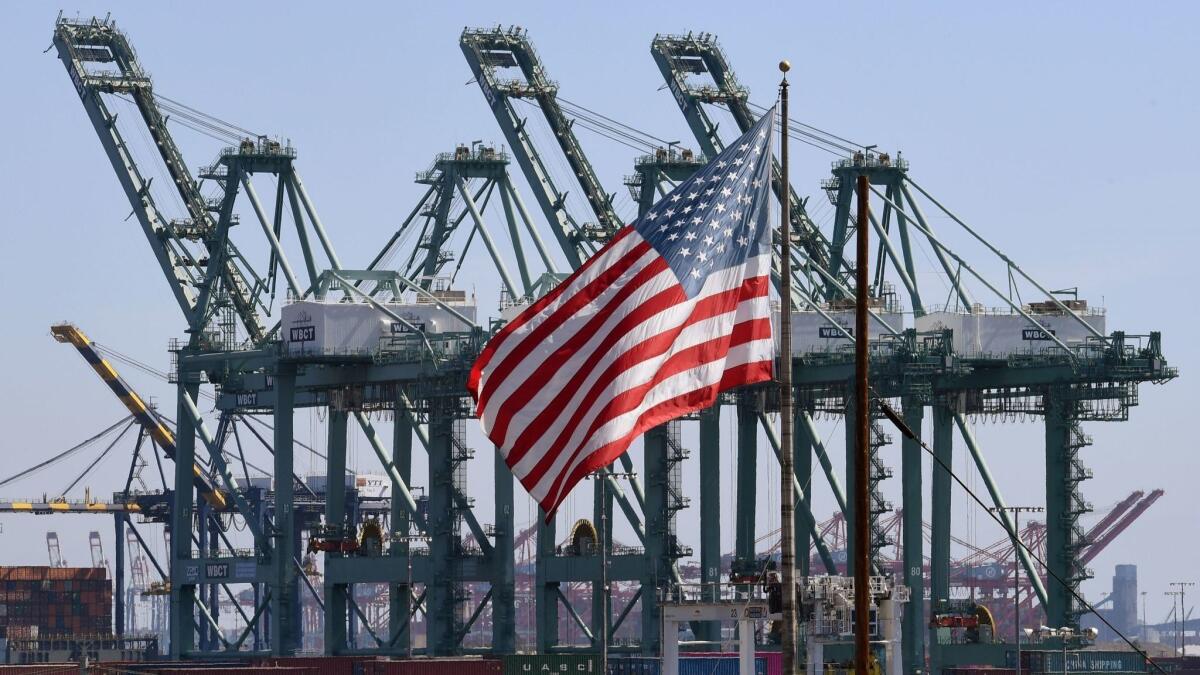 The U.S. flag flies at the Port of Long Beach. President Trump’s promised “economic boom” is unlikely to happen without major legislation, according to a White House report.