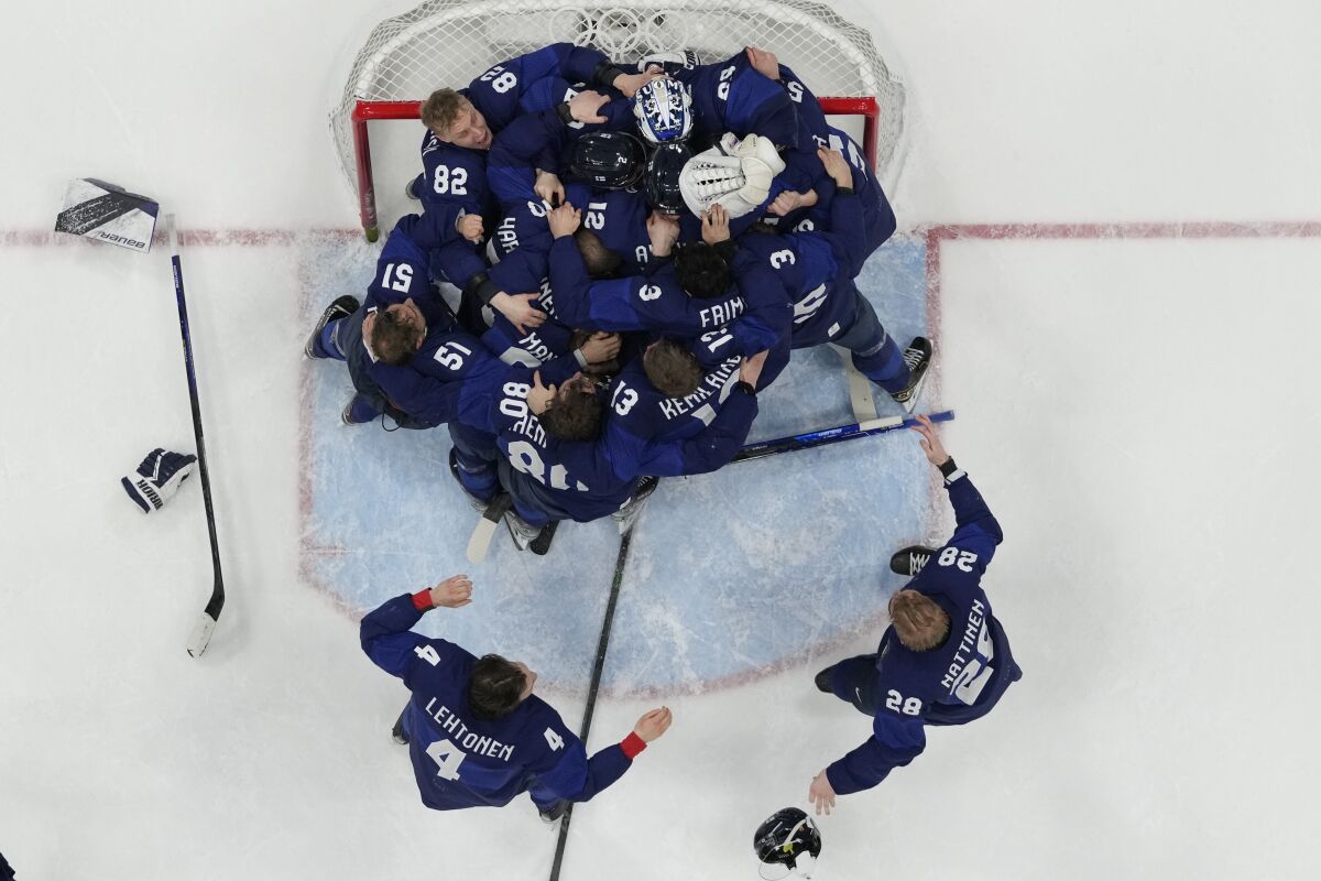 Finland players celebrate after defeating the Russian Olympic Committee.