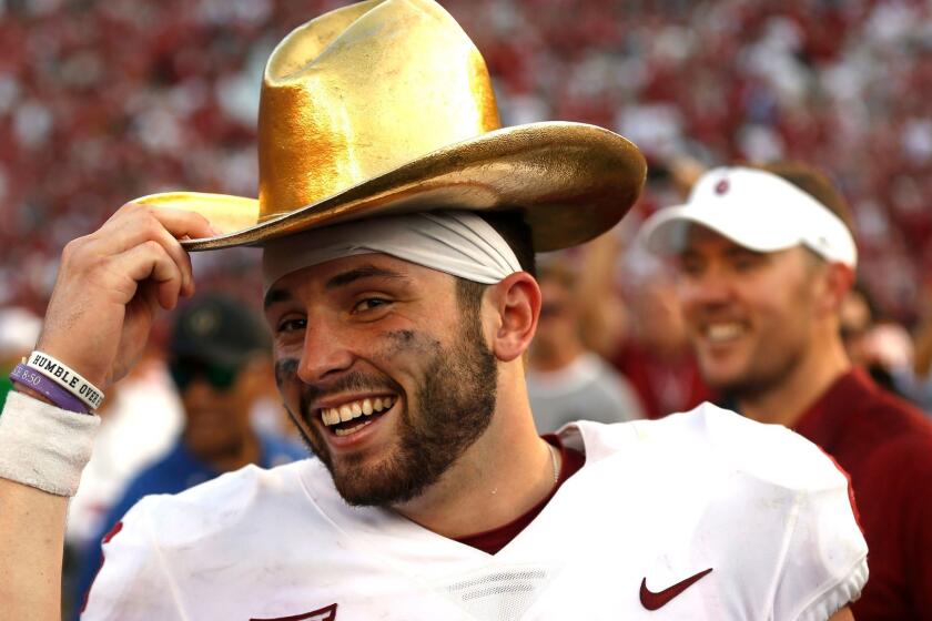 FILE - In this Oct. 14, 2017, file photo, Oklahoma quarterback Baker Mayfield (6) celebrates with the Golden Hat Trophy following the team's 29-24 win over Texas in an NCAA college football game in Dallas. Mayfield will be the first quarterback to finish in the top four of the Heisman Trophy balloting three times, and heâs favored to claim the award on Saturday. (AP Photo/Ron Jenkins, File)
