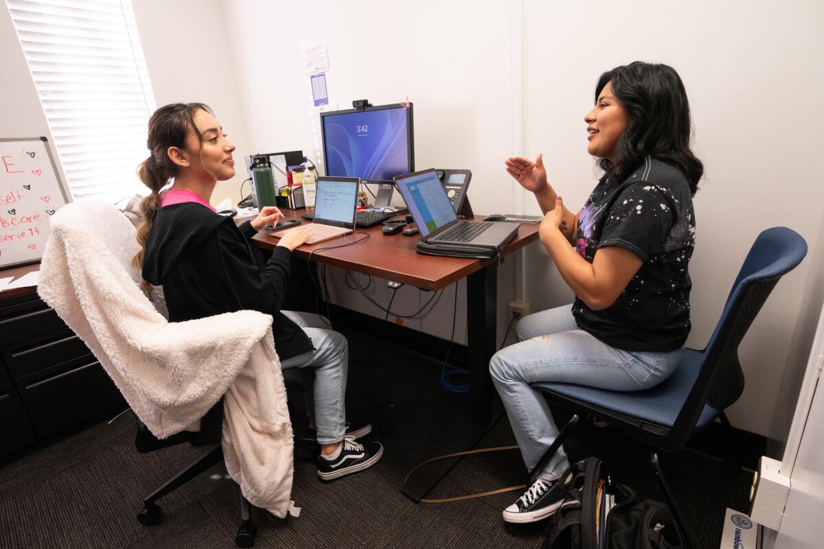 Two women confer in an office at the Dream Success Center.