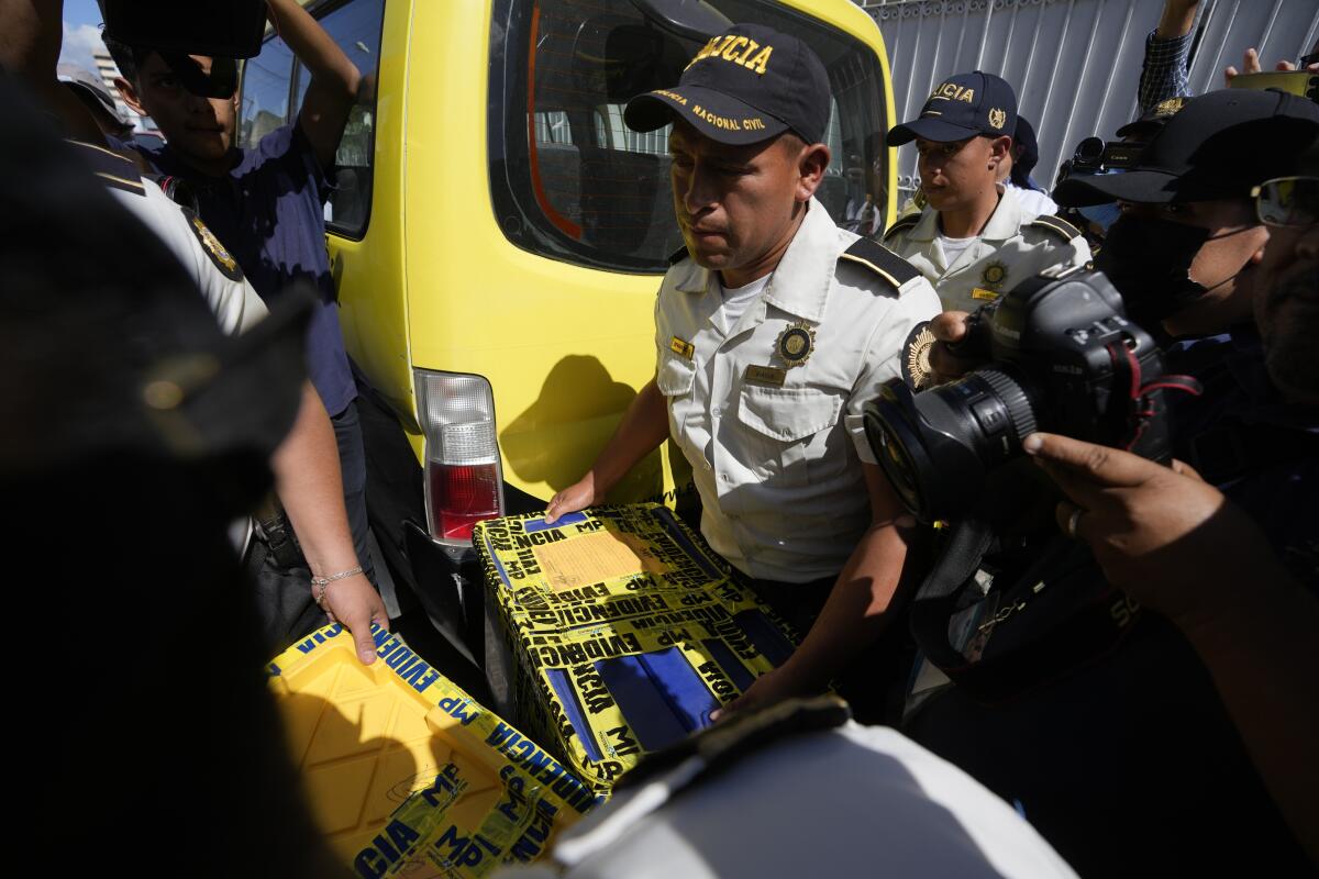 Agentes de policía cargan una caja con evidencias recogidas en la sede del Movimiento Semilla 