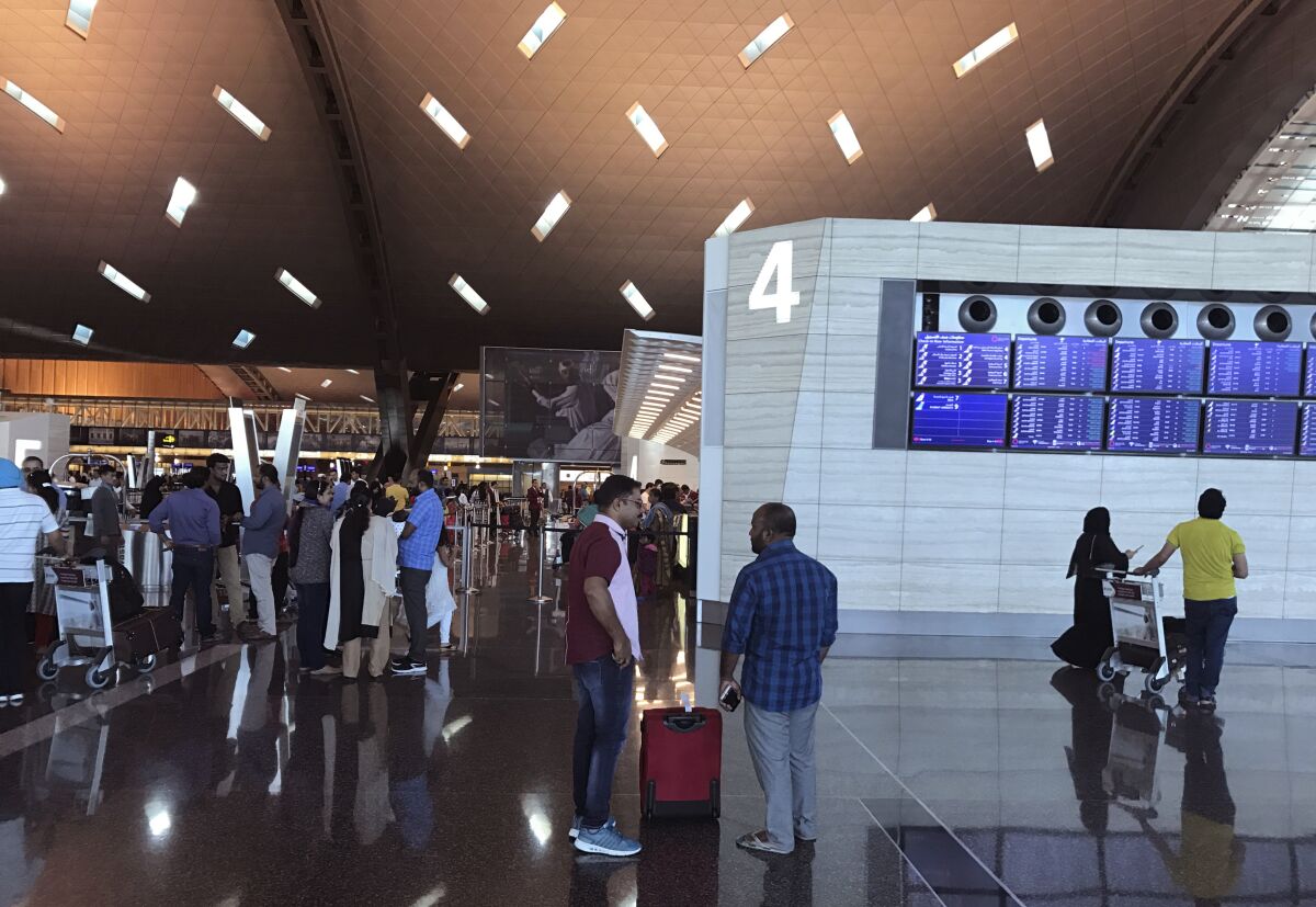 FILE - Passengers arrive at the Hamad International Airport in Doha, Qatar on June 12, 2017. A group of seven Australia-based women plan to sue Qatar's government for being forced to undergo invasive gynecological examinations at Doha's international airport after an abandoned newborn was found in a trash can there last year, their lawyer said on Monday, Nov. 15, 2021. (AP Photo/Malak Harb, File)