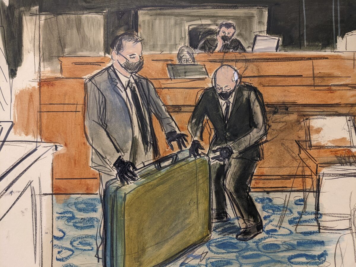 In this sketch, a prosecution detective, left, shows a massage table recovered from Jeffrey Epstein's Palm Beach Beach home to witness and former Palm Beach Police Officer Gregory Parkinson, right, during testimony in the sex-abuse trial of Ghislaine Maxwell, Friday Dec. 3, 2021, in New York. (Elizabeth Williams via AP)