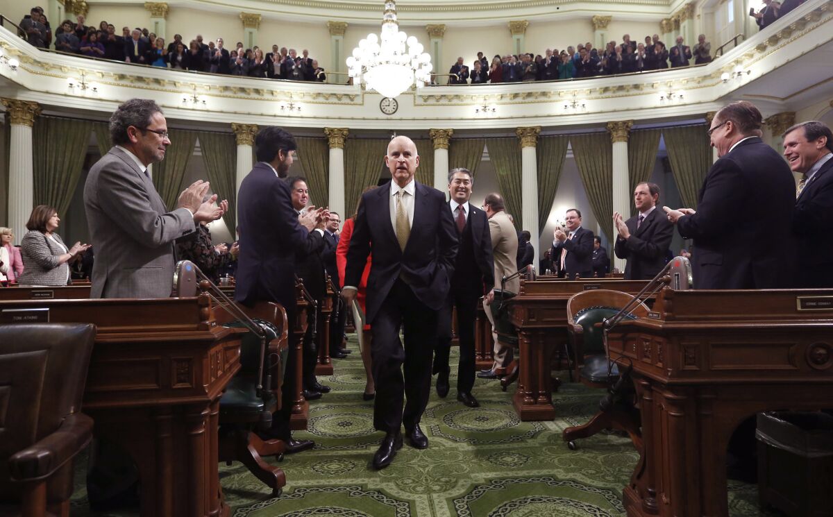 Gov. Jerry Brown receives applause from lawmakers as he walks to deliver his State of the State address at the Capitol in Sacramento last year.
