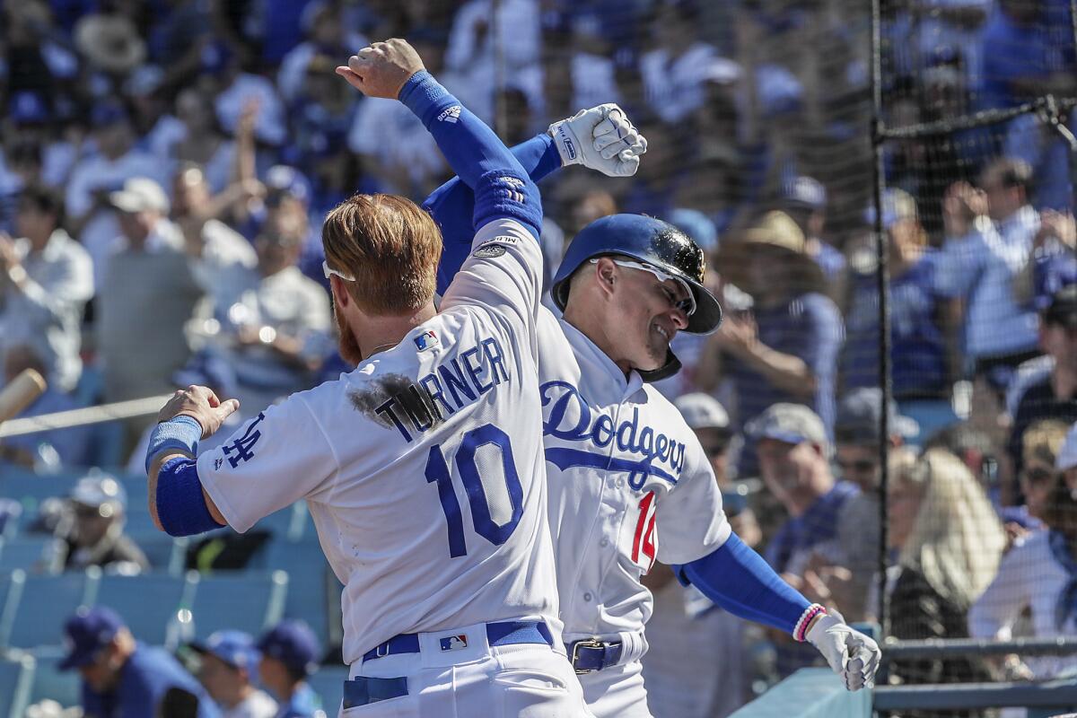 Kiké Hernandez celebrates with Dodgers teammate Justin Turner after hitting his second homer of the game in the seventh inning against the Diamondbacks at Dodger Stadium.