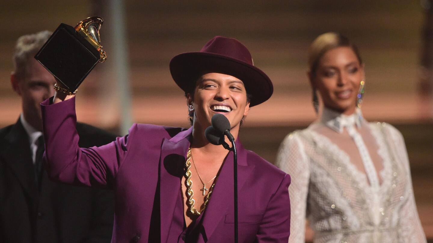 Bruno Mars holds up the award for record of the year for "Uptown Funk" as he thanks the fans.