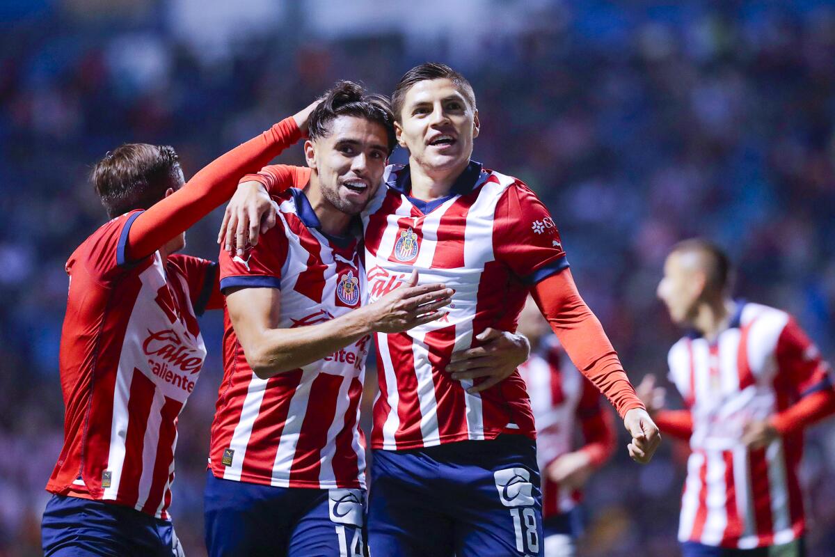 Ronaldo Cisneros (R) of Chivas celebrates with Ricardo Marin (L) after scoring 