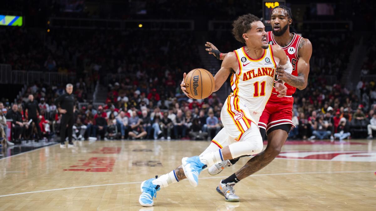 El base de los Hawks de Atlanta Trae Young avanza hacia la canasta frente al alero de los Bulls de Chicago 