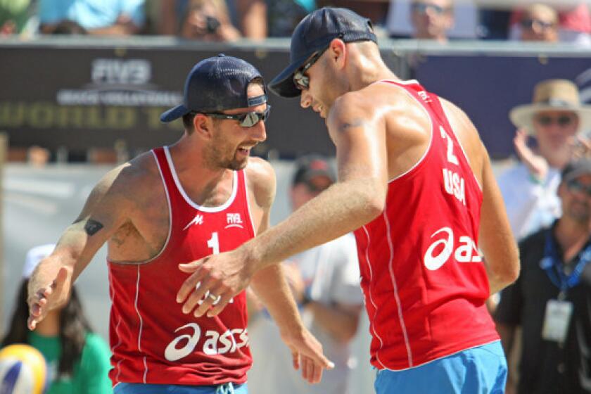 Sean Rosenthal, left, and Phil Dalhausser celebrate a point during their gold medal victory at the FIVB Grand Slam in Long Beach on Saturday.