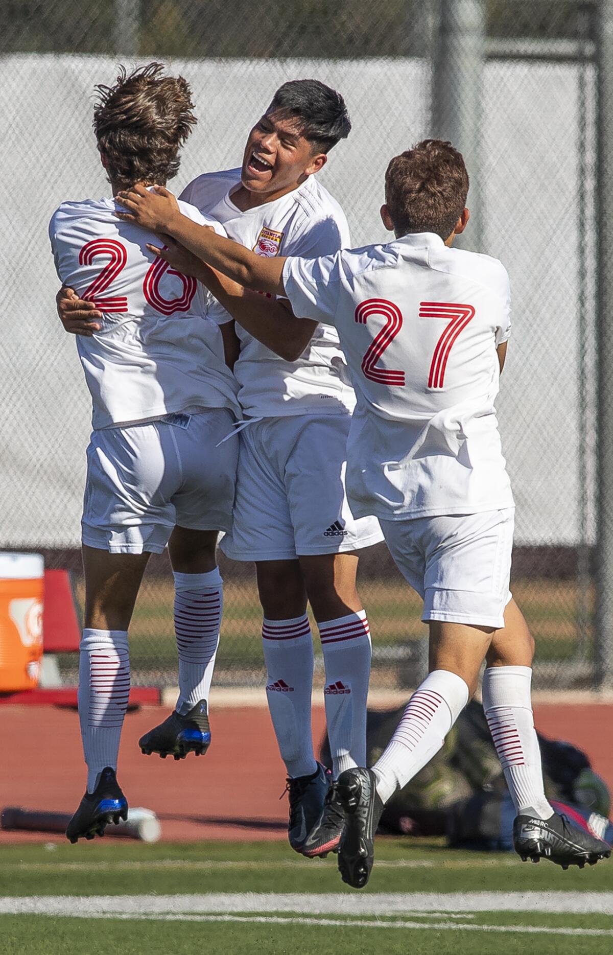 Estancia's Taylor Demarais, left, is congratulated by Edwin Raymundo, center, and another teammate during Thursday's game.