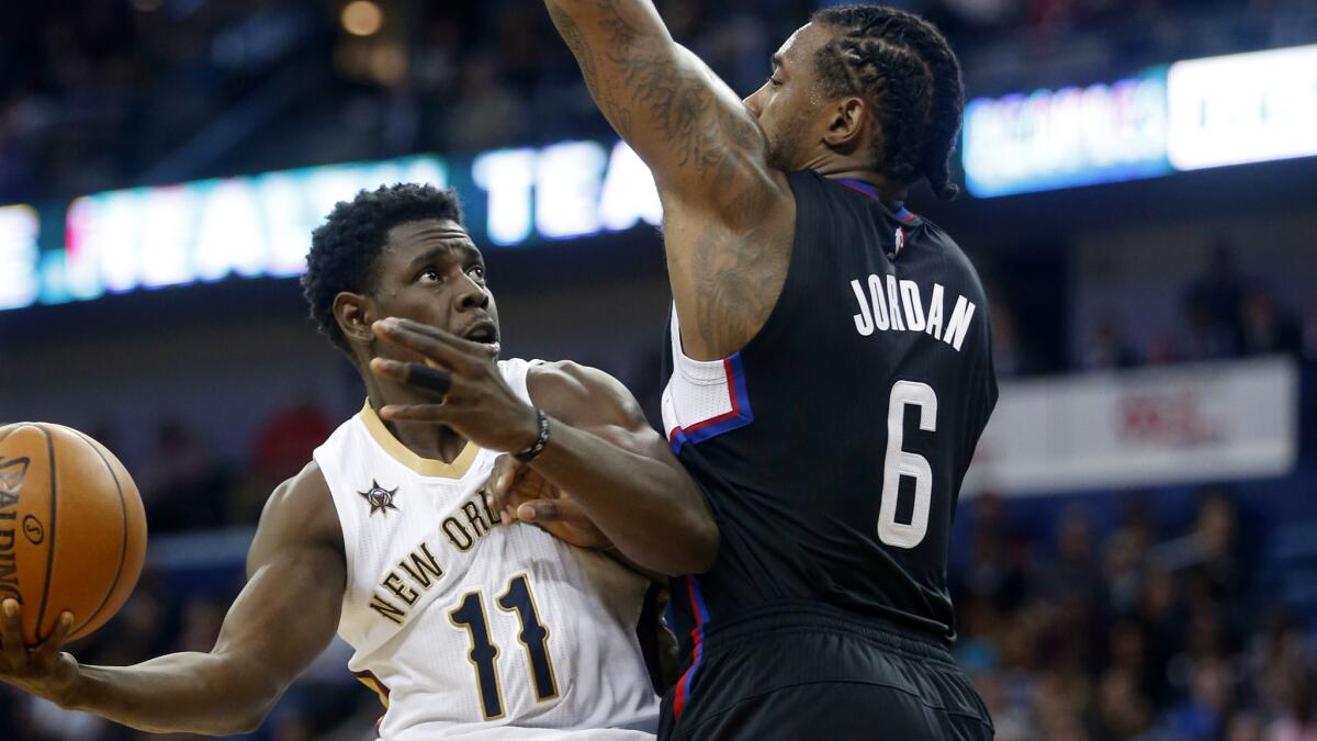 Clippers center DeAndre Jordan (6) forces Pelicans guard Jrue Holiday into an awkward shot during the second half Wednesday.